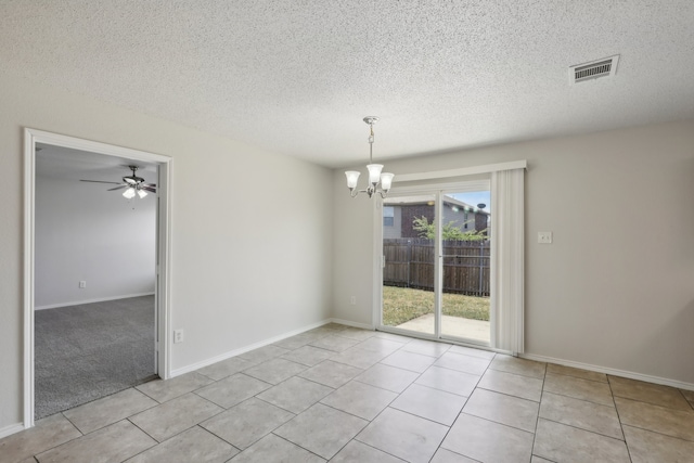 tiled spare room with ceiling fan with notable chandelier and a textured ceiling