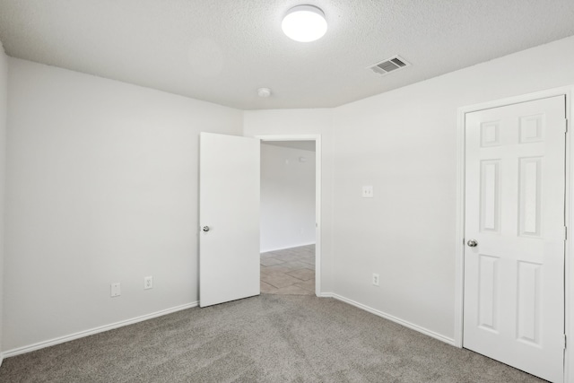 unfurnished room with carpet floors and a textured ceiling