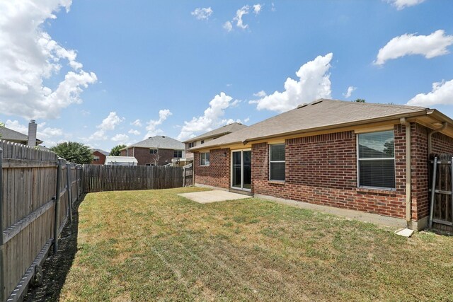 back of house with a yard and a patio