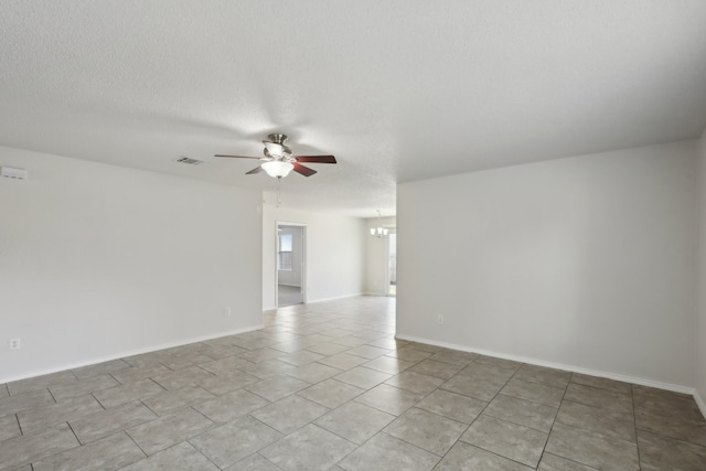 tiled spare room with a textured ceiling and ceiling fan with notable chandelier