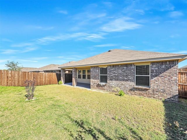 rear view of house featuring a patio area and a yard