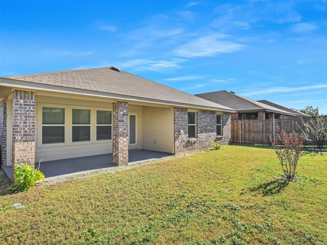 rear view of property with a yard and a patio