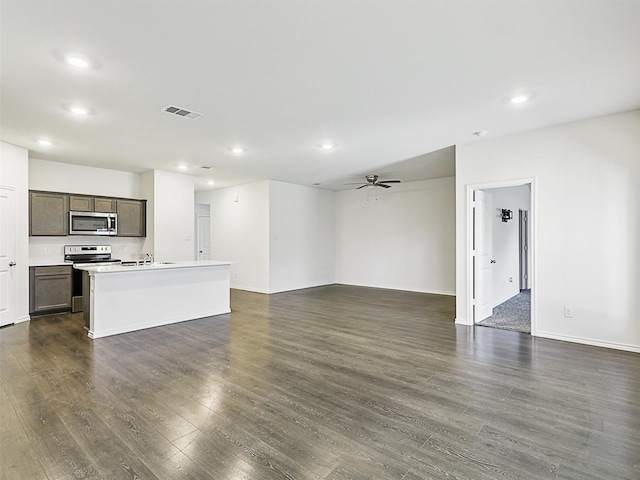 unfurnished living room with ceiling fan and dark wood-type flooring