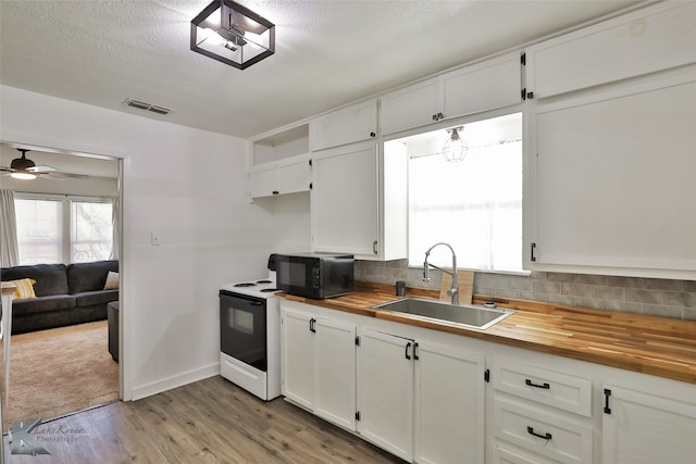 kitchen featuring wood counters, white range with electric stovetop, sink, light hardwood / wood-style flooring, and white cabinets