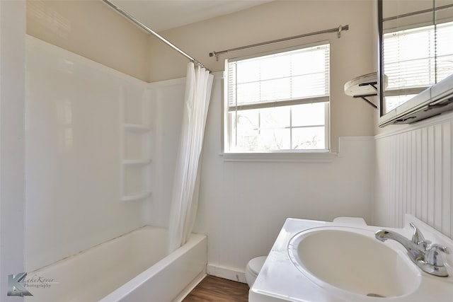 full bathroom with shower / bath combo with shower curtain, sink, wood-type flooring, and toilet