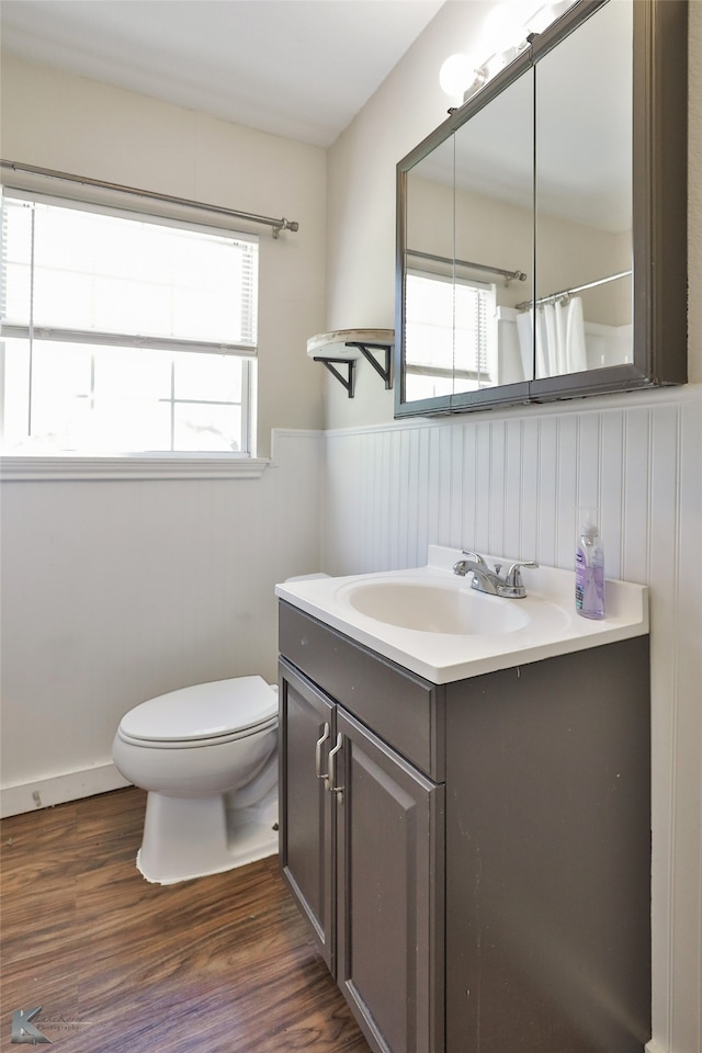 bathroom featuring a shower with shower curtain, wood-type flooring, vanity, and toilet