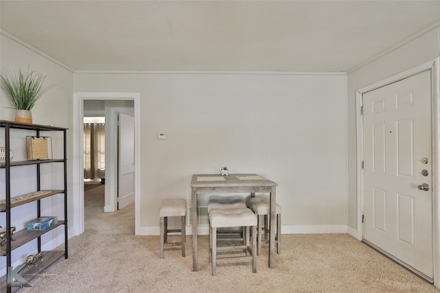 carpeted dining room with ornamental molding