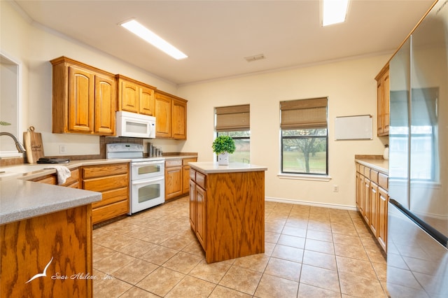 kitchen with a center island, white appliances, crown molding, sink, and light tile patterned floors