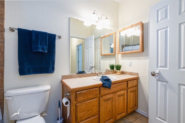 bathroom with tile patterned flooring, vanity, an inviting chandelier, and toilet