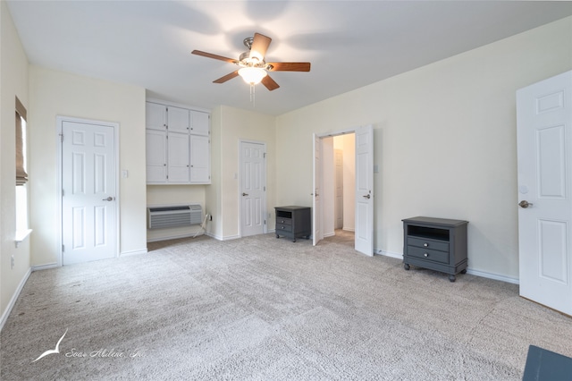 unfurnished bedroom with light carpet, a wall unit AC, and ceiling fan