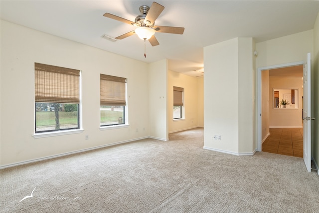 spare room featuring ceiling fan and light colored carpet