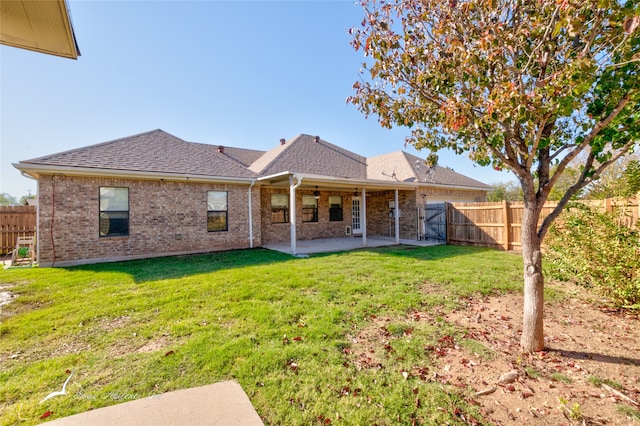 rear view of house with a patio area and a lawn