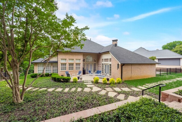 exterior space with a patio area, a front yard, and french doors