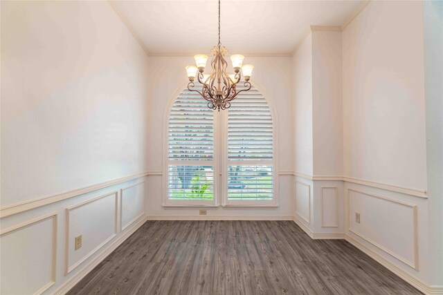 unfurnished room with dark hardwood / wood-style flooring, a chandelier, and ornamental molding