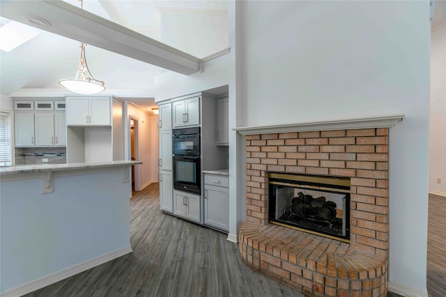 kitchen with white cabinetry, dark wood-type flooring, black double oven, pendant lighting, and decorative backsplash