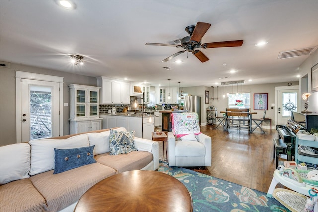 living room with ceiling fan and dark wood-type flooring