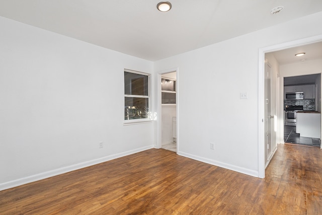 empty room with dark hardwood / wood-style flooring