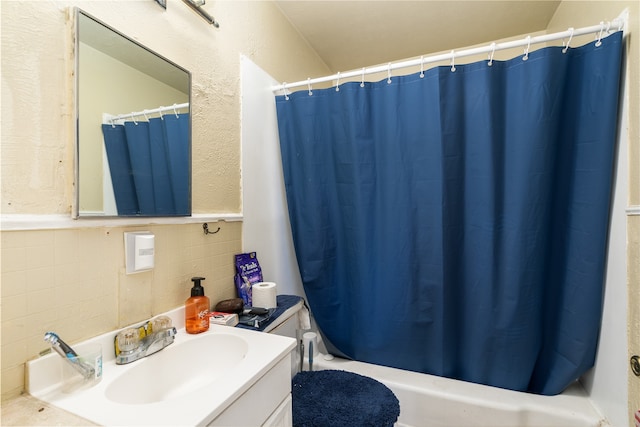 full bathroom featuring shower / tub combo with curtain, vanity, tile walls, and toilet