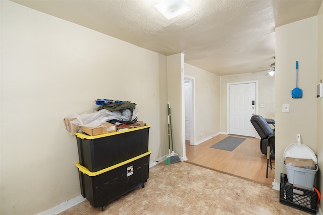 misc room with hardwood / wood-style floors, ceiling fan, and a textured ceiling