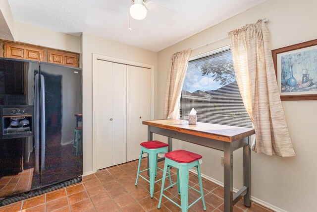 kitchen with ceiling fan and black fridge