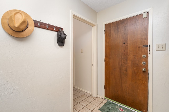 foyer with light tile patterned floors and a textured ceiling