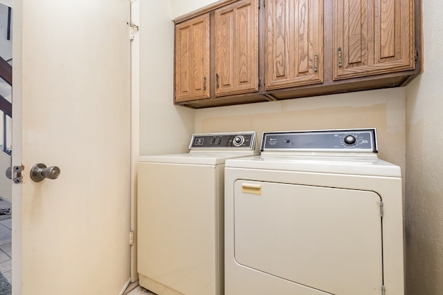 washroom with cabinets and washing machine and clothes dryer