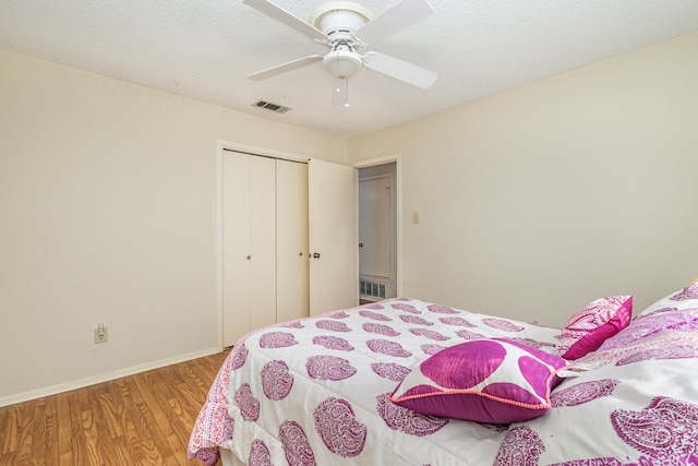 bedroom with wood-type flooring, a textured ceiling, a closet, and ceiling fan