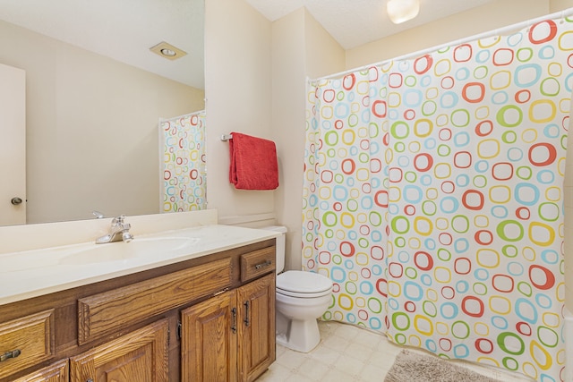 bathroom featuring vanity, a textured ceiling, and toilet