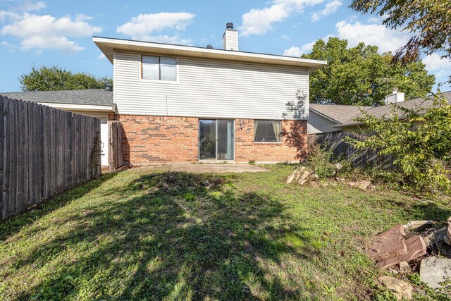 back of property featuring a patio area and a lawn