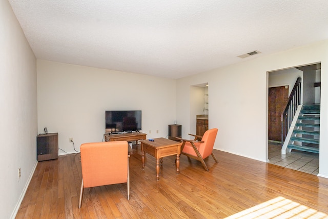 living room featuring hardwood / wood-style floors and a textured ceiling