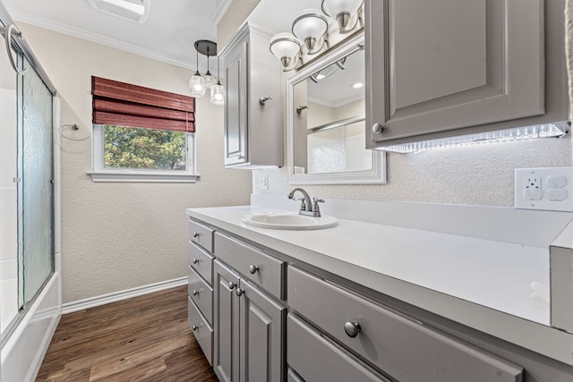 bathroom featuring hardwood / wood-style floors, vanity, enclosed tub / shower combo, and ornamental molding