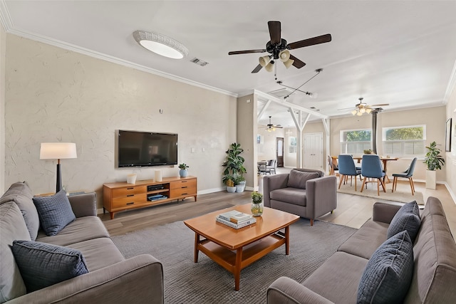 living room with crown molding, ceiling fan, and wood-type flooring