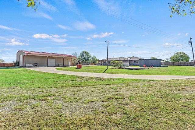 view of yard with a garage and an outbuilding