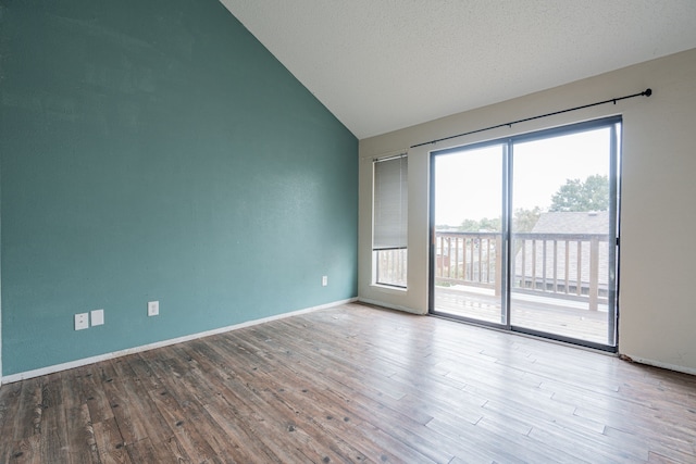 spare room with a textured ceiling, light hardwood / wood-style flooring, and vaulted ceiling