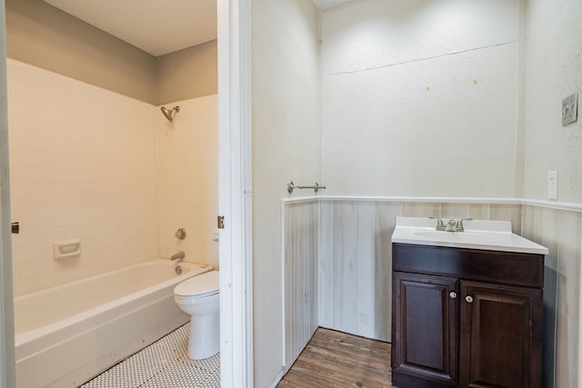 full bathroom with vanity, wood-type flooring, tiled shower / bath combo, and toilet