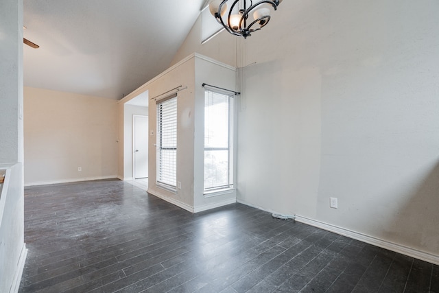 spare room with dark hardwood / wood-style flooring, vaulted ceiling, and a notable chandelier