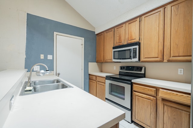 kitchen with sink, light tile patterned flooring, vaulted ceiling, and appliances with stainless steel finishes