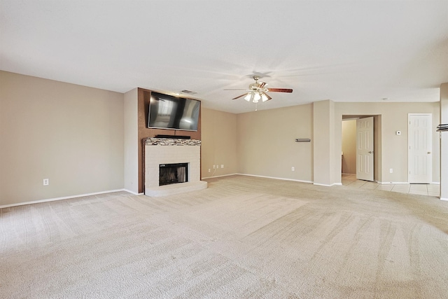 unfurnished living room featuring a fireplace, ceiling fan, and light carpet