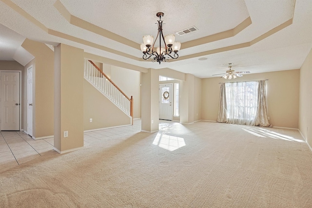 interior space featuring a tray ceiling, a textured ceiling, and ceiling fan with notable chandelier