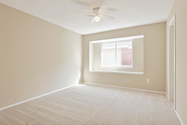 empty room featuring ceiling fan, light colored carpet, and a textured ceiling