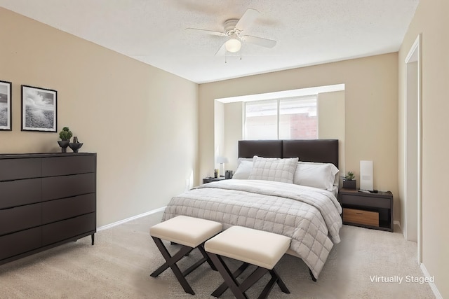 carpeted bedroom featuring ceiling fan and a textured ceiling