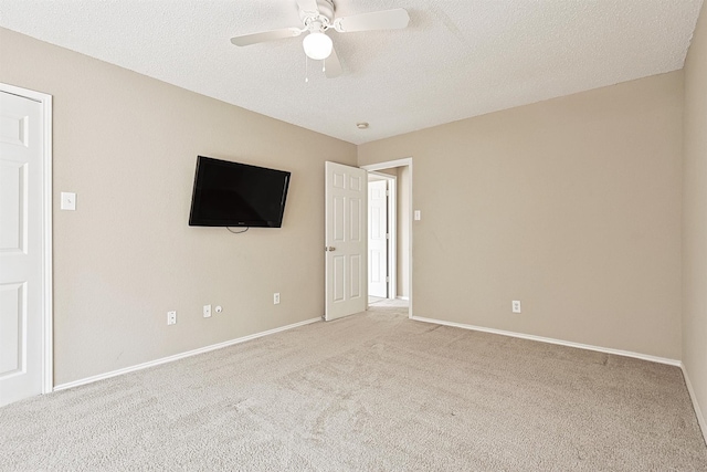 carpeted spare room featuring ceiling fan and a textured ceiling