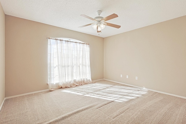 spare room featuring ceiling fan, carpet, and a textured ceiling