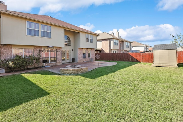 back of property featuring a gazebo, an outdoor fire pit, a patio, a shed, and a lawn