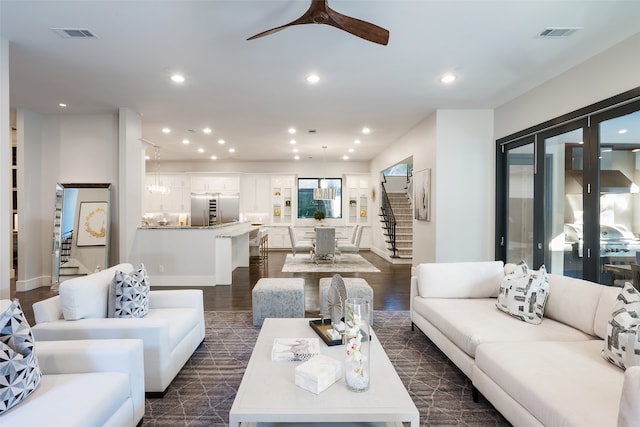 living room featuring ceiling fan and dark wood-type flooring