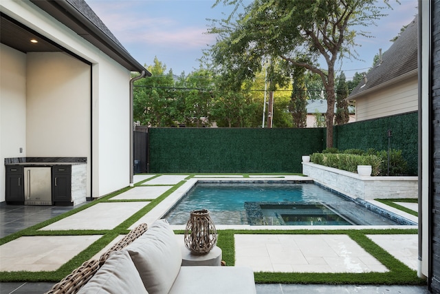 view of pool featuring an in ground hot tub and a patio