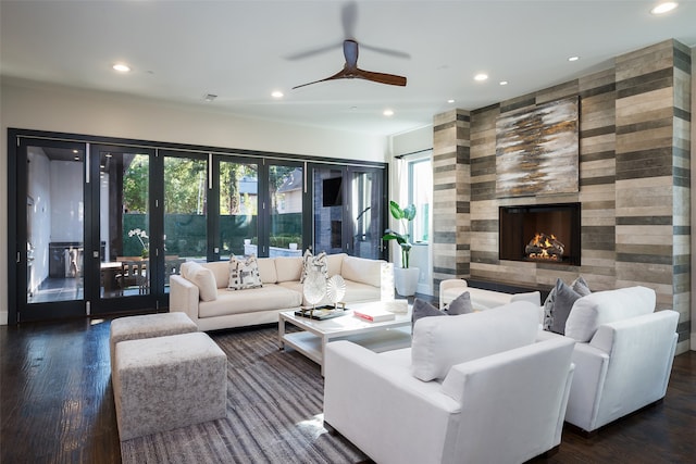 living room with dark hardwood / wood-style floors, ceiling fan, and a tiled fireplace