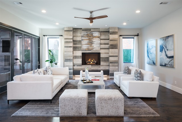 living room with ceiling fan, a fireplace, and dark hardwood / wood-style floors