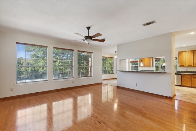 unfurnished living room featuring ceiling fan, light hardwood / wood-style floors, and a wealth of natural light