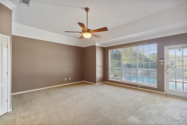 spare room featuring light colored carpet, ceiling fan, and crown molding